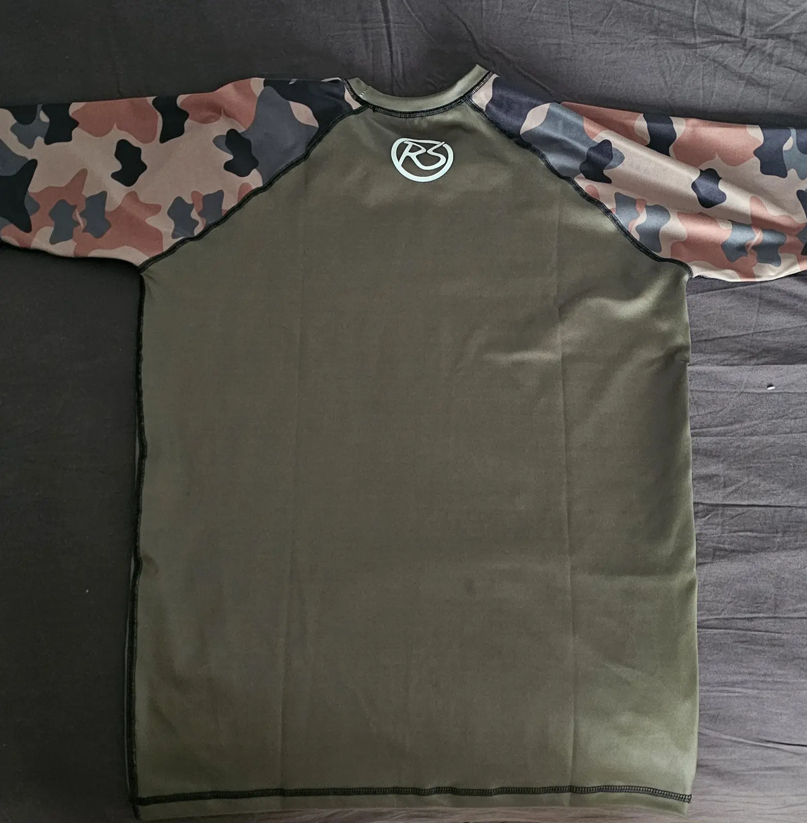 Rashguard real visto por la espalda con monograma RS bajo el cuello